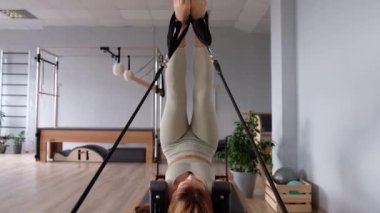Kadın, ıslah yatağında pilates eğitiyor. Beden eğitimi için pilates stüdyosu makinesi. Formda, sağlıklı ve güçlü özgün bir vücut. Fitness konsepti. 