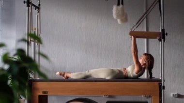 Pilates fitness antrenörü pilates stüdyosunda egzersiz yapıyor. Spor salonunda spor yapmak için dengeli vücut Cadillac 'ı. Formda, sağlıklı ve güçlü özgün bir vücut. Fitness konsepti