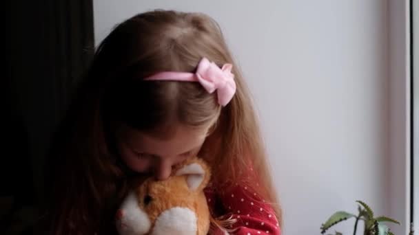 Menina Sentada Abraçando Seu Brinquedo Olhando Através Janela Inverno Ficar — Vídeo de Stock