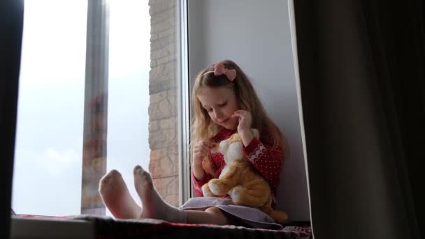 Petite Fille Assise Étreignant Son Jouet Regardant Par Fenêtre Concept — Video