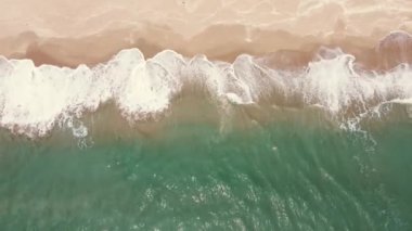 Yaz mevsimi deniz manzarası güzel dalgalar, güneşli bir günde mavi deniz suyu. Üst Manzara. Deniz insansız hava aracı görüntüsü, inanılmaz tropikal doğa arka planı. Su sıçratan dalgalar ve kumsal kum konseptiyle güzel, parlak deniz.
