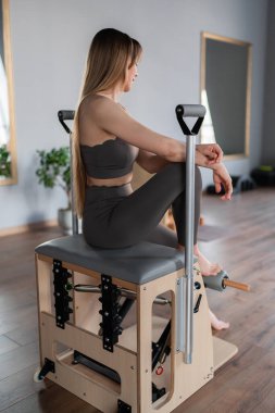Pilates stüdyosunda spor eğitmeni. Yoga stüdyosunda spor kıyafeti giyen çekici genç bir kadın. Formda, sağlıklı ve güçlü özgün bir vücut. Fitness konsepti. 