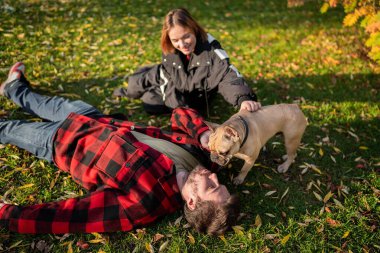 Mutlu çift yapraklarla dolu güzel bir sonbahar parkında köpekleriyle güzel vakit geçiriyor..