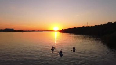 Suda bir grup kız aynı anda SAP kurulunda kürek çekiyor. Yüksek kaliteli FullHD görüntüler