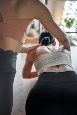 Yoğun bir pilates seansı, bir eğitmenin öğrenciye yenilikçi teçhizat kullanarak ustalıkla rehberlik etmesiyle gerçekleşir.