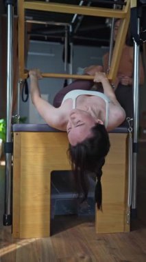 Tepetaklak bir şekilde pilates yapan bir kadın etkileyici bir güç, esneklik ve denge sergiliyor.