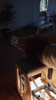 Parlak, davetkar bir stüdyo içinde dinamik güç eğitimi veren odaklanmış bir pilates seansı deneyin.