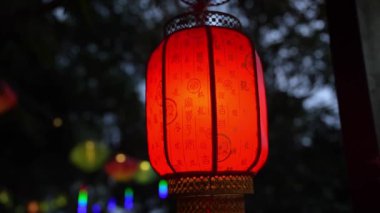 Güzel, canlı kırmızı fenerler dışarıda asılı duruyor, alacakaranlıkta büyüleyici ve neşeli bir atmosfer yaratıyorlar.