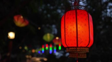 Güzel, canlı kırmızı fenerler dışarıda asılı duruyor, alacakaranlıkta büyüleyici ve neşeli bir atmosfer yaratıyorlar.