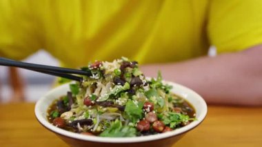 Kıtır fıstık, taze otlar ve fasulye filizleriyle süslenmiş baharatlı şehriye salatasının tadını çıkarın.