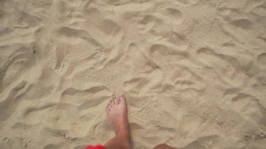 Kumsalda güneşli bir günün sıcağında çıplak ayaklarımla ayaklarımın altındaki yumuşak, sıcak kumların tadını çıkarıyorum.