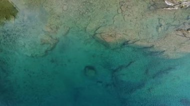 Kuş bakışı bir bakışla, bir dron huzurlu gök mavisi sularını yakalar, sükunet ve rahatlama duygularını ortaya çıkarır.