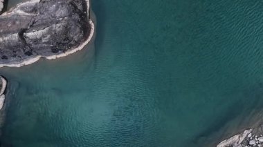 Kuş bakışı bir bakışla, bir dron huzurlu gök mavisi sularını yakalar, sükunet ve rahatlama duygularını ortaya çıkarır.
