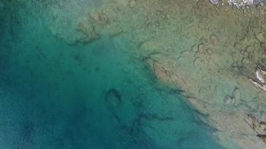 Kuş bakışı bir bakışla, bir dron huzurlu gök mavisi sularını yakalar, sükunet ve rahatlama duygularını ortaya çıkarır.