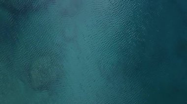 Kuş bakışı bir bakışla, bir dron huzurlu gök mavisi sularını yakalar, sükunet ve rahatlama duygularını ortaya çıkarır.