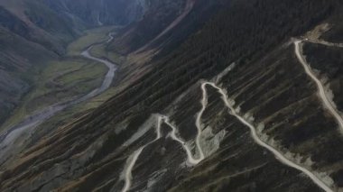 Altai 'nin tehlikeli dağlarındaki yılan yolunun havadan manzarası. Kayalık dağlardaki turist yolu Rusya 'da tehlikelidir. Yüksek kalite 4K görüntü. Yüksek kalite 4k görüntü