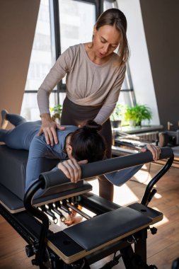 Göğüs ve sırt kasları için Kuğu egzersizi yapan kadın, esneklik, güç ve kararlılıkla kontrol üzerine odaklanıyor.