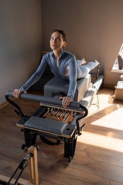 Göğüs ve sırt kasları için Kuğu egzersizi yapan kadın, esneklik, güç ve kararlılıkla kontrol üzerine odaklanıyor.