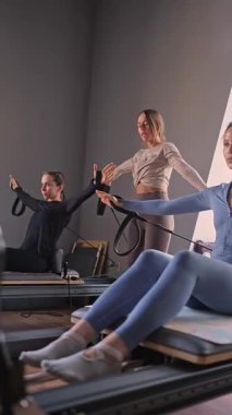 Kadın, ıslah yatağında pilates eğitiyor. Beden eğitimi için pilates stüdyosu makinesi. Formda, sağlıklı ve güçlü özgün bir vücut. Fitness konsepti