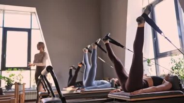 Dengeli Vücut Reformcusu makinesinin güneş ışığıyla aydınlatılan ayak ve çekirdek egzersizinin detaylı bir yakın çekimi. Yüksek kalite fotoğraf