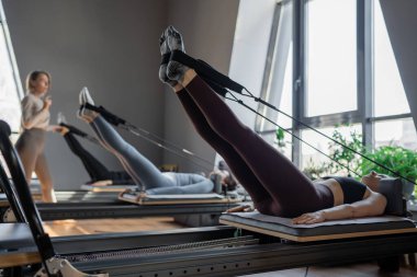 Dengeli Vücut Reformcusu makinesinin güneş ışığıyla aydınlatılan ayak ve çekirdek egzersizinin detaylı bir yakın çekimi. Yüksek kalite fotoğraf