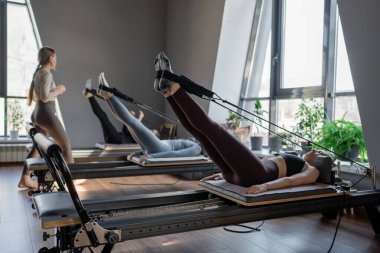 Dengeli Vücut Reformcusu makinesinin güneş ışığıyla aydınlatılan ayak ve çekirdek egzersizinin detaylı bir yakın çekimi. Yüksek kalite fotoğraf