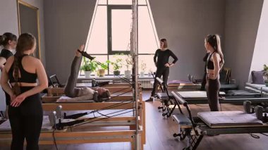 Kadın, ıslah yatağında pilates eğitiyor. Beden eğitimi için pilates stüdyosu makinesi. Formda, sağlıklı ve güçlü özgün bir vücut. Fitness konsepti