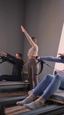 Kadın, ıslah yatağında pilates eğitiyor. Beden eğitimi için pilates stüdyosu makinesi. Formda, sağlıklı ve güçlü özgün bir vücut. Fitness konsepti