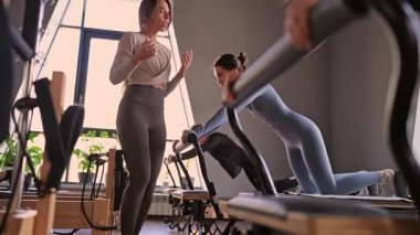 Kadın, ıslah yatağında pilates eğitiyor. Beden eğitimi için pilates stüdyosu makinesi. Formda, sağlıklı ve güçlü özgün bir vücut. Fitness konsepti
