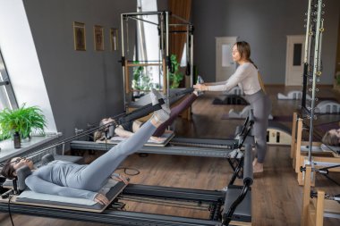 Dengeli Vücut Reformcusu makinesinin güneş ışığıyla aydınlatılan ayak ve çekirdek egzersizinin detaylı bir yakın çekimi. Yüksek kalite fotoğraf