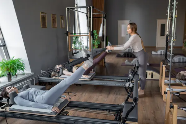 Dengeli Vücut Reformcusu makinesinin güneş ışığıyla aydınlatılan ayak ve çekirdek egzersizinin detaylı bir yakın çekimi. Yüksek kalite fotoğraf