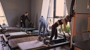 Kadın, ıslah yatağında pilates eğitiyor. Beden eğitimi için pilates stüdyosu makinesi. Formda, sağlıklı ve güçlü özgün bir vücut. Fitness konsepti