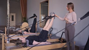 Dengeli Vücut Reformcusu makinesinin güneş ışığıyla aydınlatılan ayak ve çekirdek egzersizinin detaylı bir yakın çekimi. Yüksek kalite fotoğraf