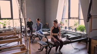 Kadın, ıslah yatağında pilates eğitiyor. Beden eğitimi için pilates stüdyosu makinesi. Formda, sağlıklı ve güçlü özgün bir vücut. Fitness konsepti