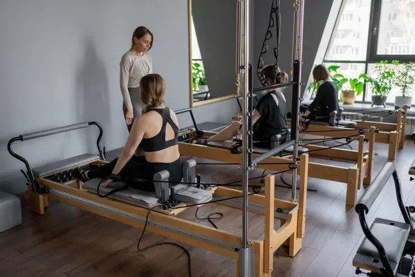 Kadın, ıslah yatağında pilates eğitiyor. Beden eğitimi için pilates stüdyosu makinesi. Formda, sağlıklı ve güçlü özgün bir vücut. Fitness konsepti. Yüksek kalite fotoğraf