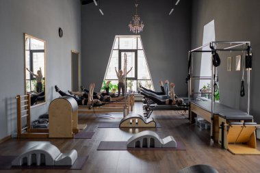 Kadın, ıslah yatağında pilates eğitiyor. Beden eğitimi için pilates stüdyosu makinesi. Formda, sağlıklı ve güçlü özgün bir vücut. Fitness konsepti