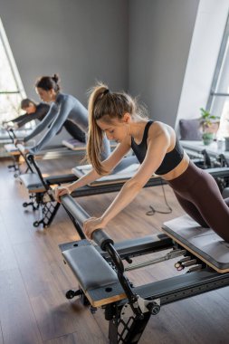 Kadın, ıslah yatağında pilates eğitiyor. Beden eğitimi için pilates stüdyosu makinesi. Formda, sağlıklı ve güçlü özgün bir vücut. Fitness konsepti. Yüksek kalite fotoğraf