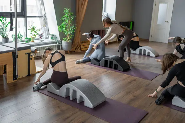 Omurga düzelticisi üzerinde denizkızı egzersizi yapan bir kadın. Beden eğitimi için pilates stüdyosu makinesi. Formda, sağlıklı ve güçlü özgün bir vücut. Fitness konsepti