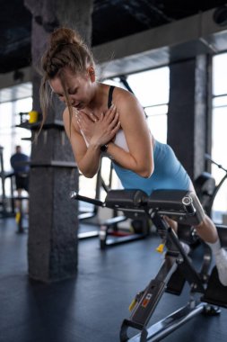 Kendini spora adamış bir kadın spor makinesinin üzerinde güçlü bir egzersiz yapar. Gücünü ve formülünü gösterir.