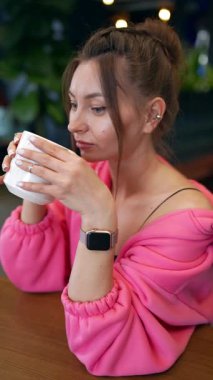 Rahatlamış bir kadın sabahları kahve koklarken evdeki oturma odasında oturuyor. Yüksek kalite fotoğraf