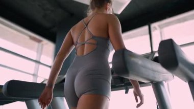 Spor salonunda koşu bandında egzersiz yapan genç bir kadın. Koşu bandında koşan aktif genç bir kadın.