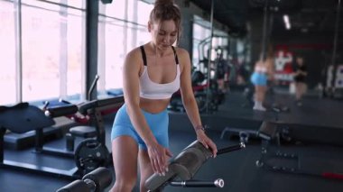 Kendini adamış bir fitness meraklısı modern, çağdaş bir spor salonunda yoğun bir egzersiz yapıyor.