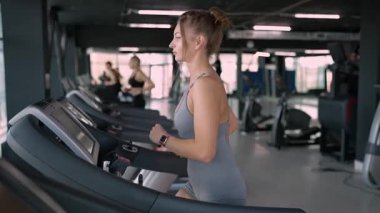 Koşu bandında koşan güzel kaslı kadının yan görüntüsü. Yüksek kalite fotoğraf