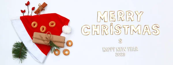 圣诞快乐 新年快乐2023 圣诞贺卡或横幅 白底红帽 云杉枝条 百吉饼和肉桂管 — 图库照片