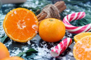 Noel kompozisyonu, mandalina, tarçın tüpleri ve şeker kamışı köknar dallarının arka planında