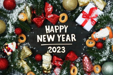 Mutlu yıllar 2023. Parlak Noel süslemeleri, köknar dalları ve tebrik metinleriyle Noel kompozisyonu