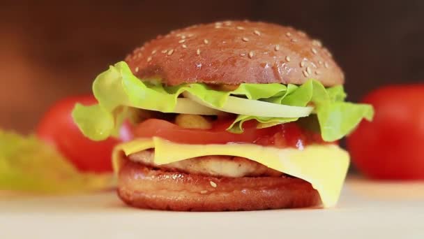 カツと新鮮な食材を使ったおいしいジューシーなバーガー おいしいチーズバーガー 対象物からカメラをスムーズに遠ざけて — ストック動画