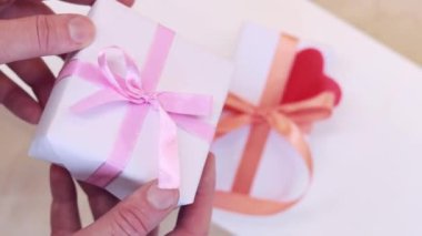 Gift for Valentine's Day, birthday or Mother's Day. White box with ribbon bow. Gift in hand, close up