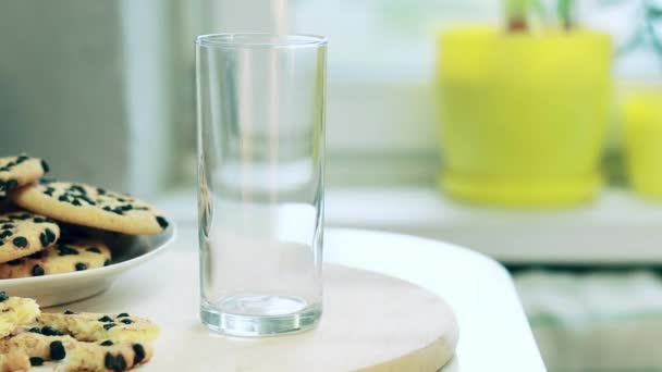 牛乳をグラスに注ぐ ミルクとおいしいチョコレートチップクッキーのガラス カルシウムの天然源 — ストック動画