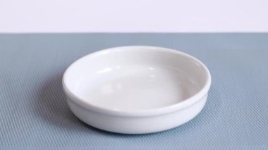 The feed is poured into a white bowl. Balanced nutrition for pets, food advertising. A bowl on a special rug